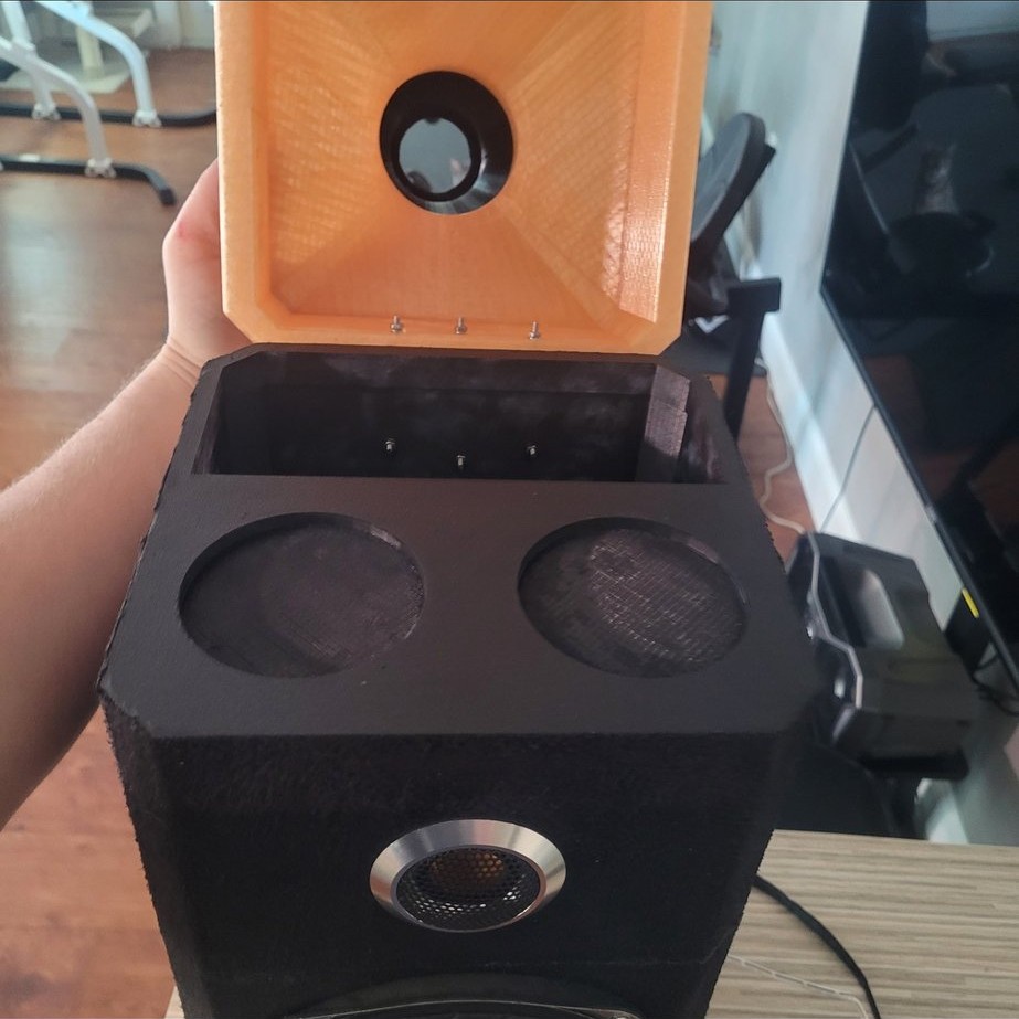 Top compartment open showing cup holder cutouts and tweeter
