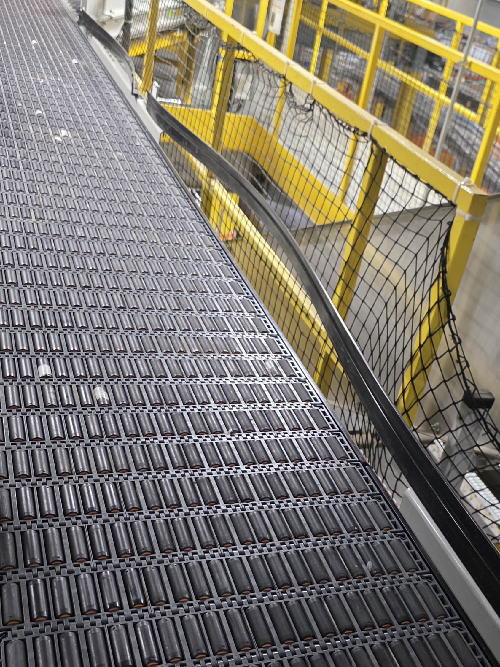 Existing guard rail bowing outward from the conveyor edge